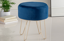 Hamilton Mcbride royal blue velvet upholstered stool with gold metal legs on a plain white tiled floor